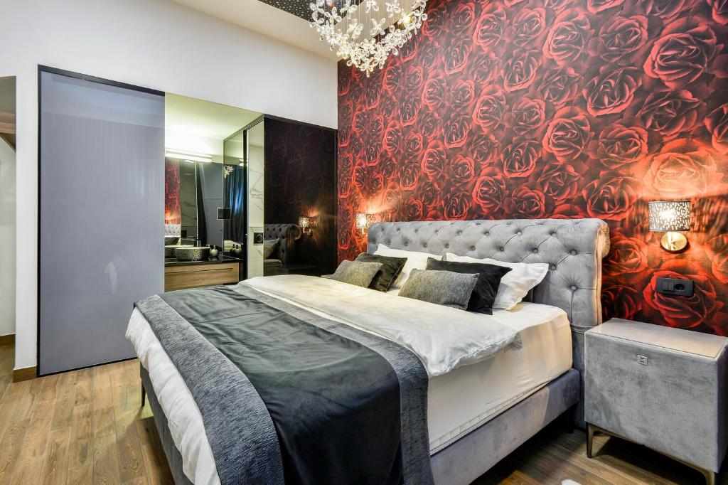 ein Schlafzimmer mit einem großen Bett und einer roten Wand in der Unterkunft Florek & Florica Room001 in Križevci