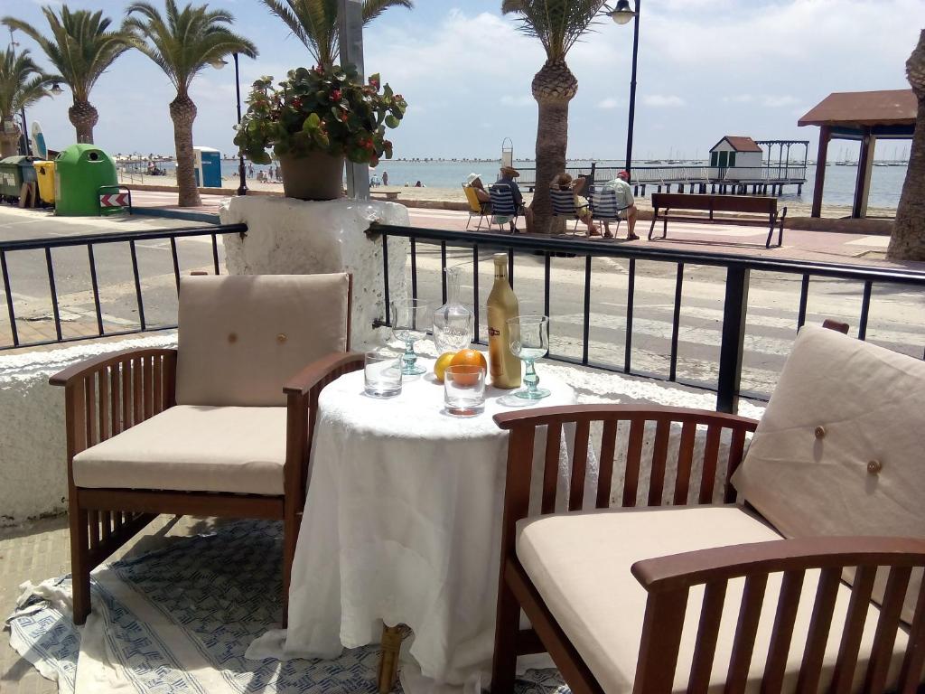a table and chairs with a table and a view of the beach at casa frente al mar in San Pedro del Pinatar