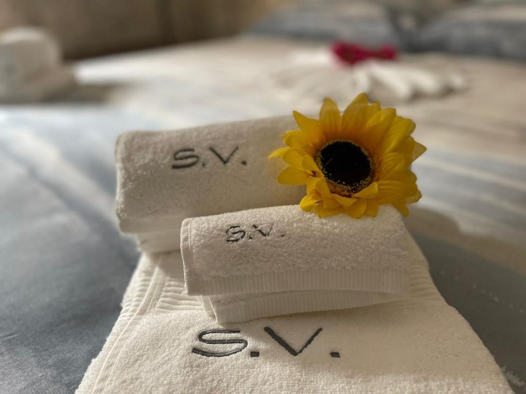 a sunflower on a towel on a bed at Sentieri Velati in Modica