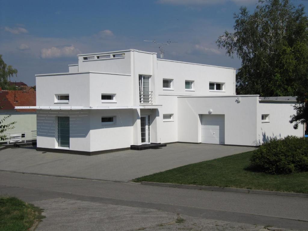 une maison blanche avec une grande allée. dans l'établissement Vinařství Novotný, à Čejkovice