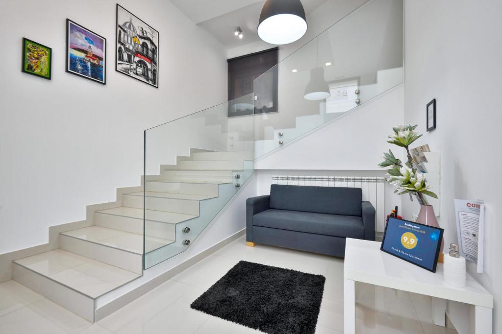 uma sala de estar com escadas e um sofá azul em Florek & Florica Apartment em Križevci