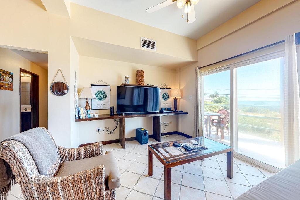 sala de estar con TV y mesa de cristal en Suite D201 at Mara Laguna Gold Standard Certified, en San Pedro
