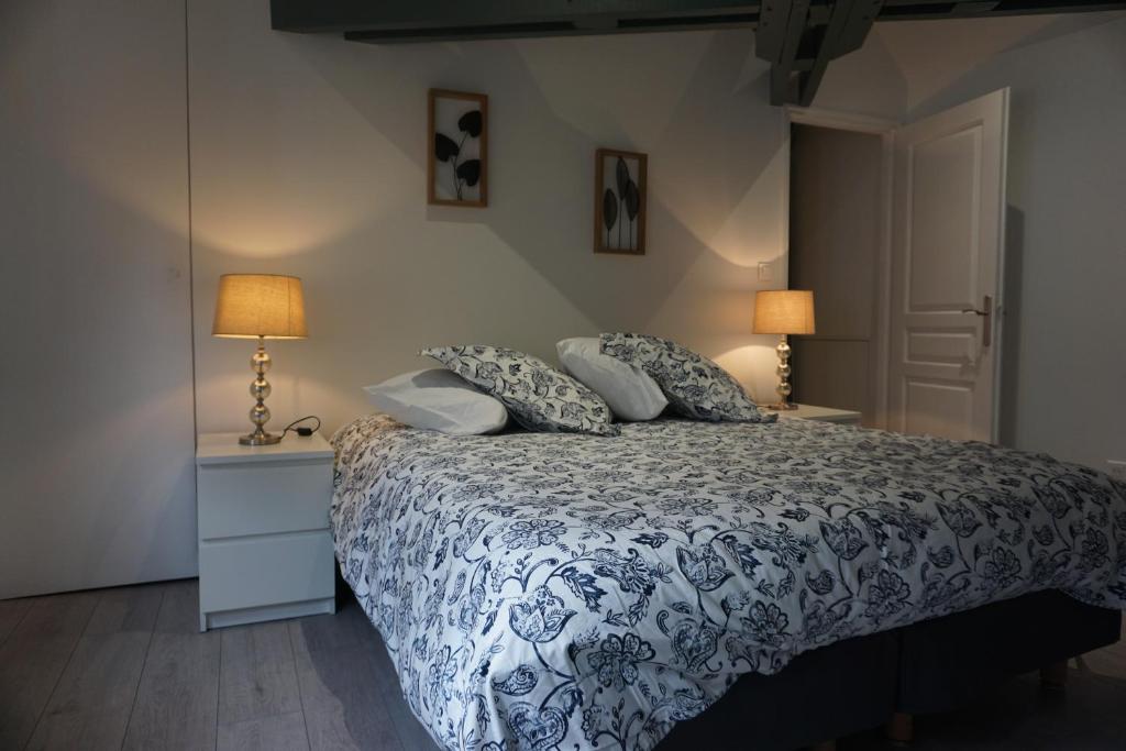 a bedroom with a bed with a blue and white comforter at Les 3 rois in Romorantin