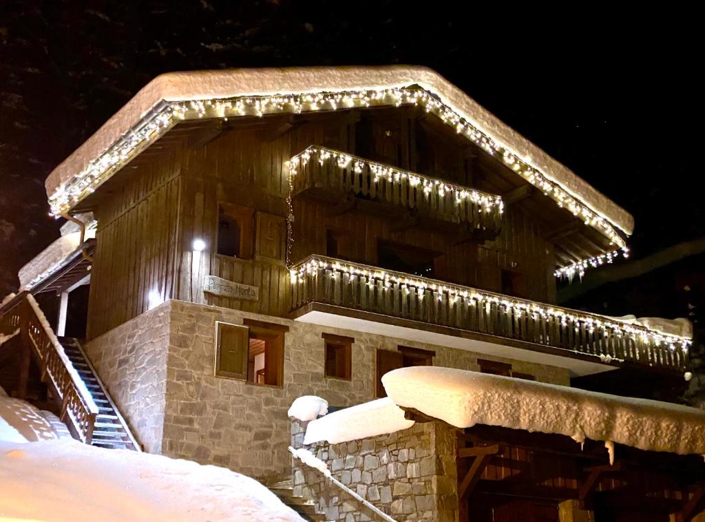budynek pokryty światłami świątecznymi w śniegu w obiekcie Fabulous chalet La Plagne - ski in-ski out - Sauna with Mont Blanc view w mieście La Plagne Tarentaise