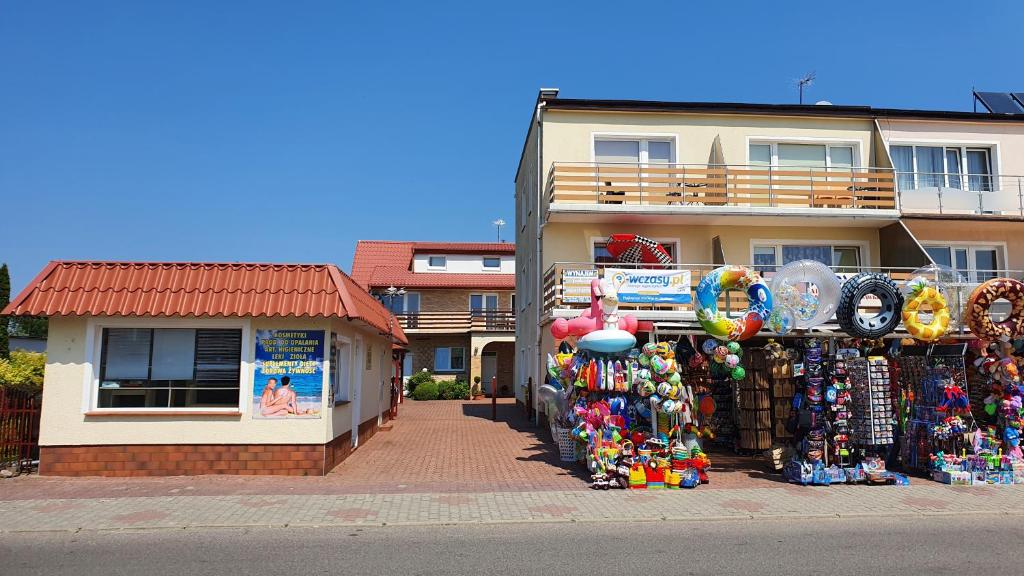 a store with a lot of merchandise in front of a building at ADANIA in Grzybowo