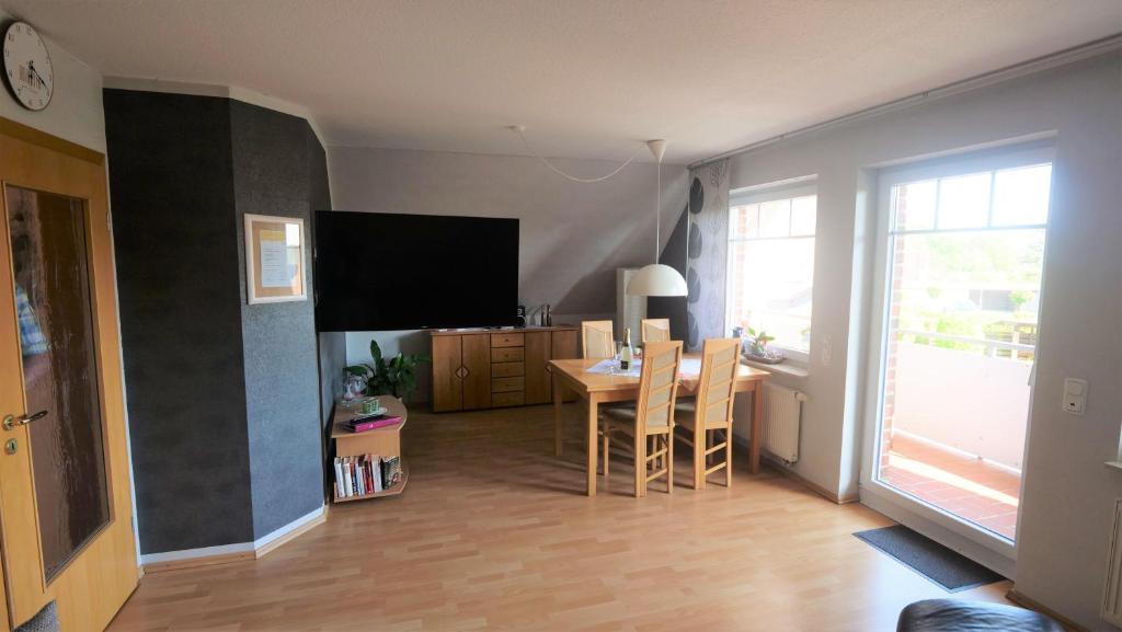 a living room with a table and a television at Ferienwohnung-Amanda-1 in Bad Zwischenahn