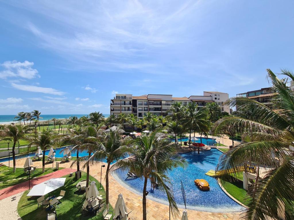 an aerial view of a resort swimming pool with palm trees at Beach Living Vista Mar - 3 Quartos - Pé na Areia in Aquiraz