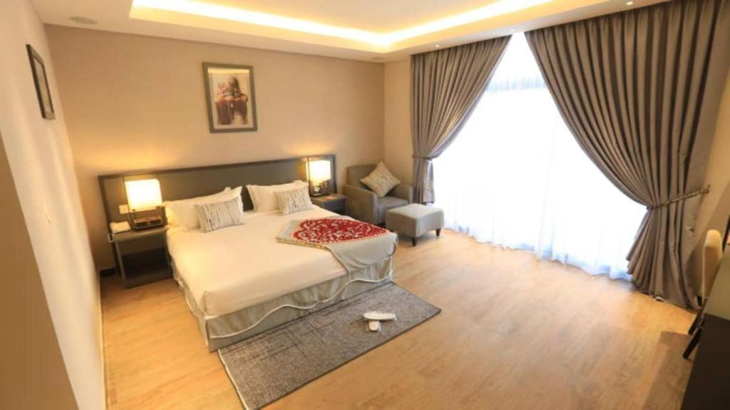 een slaapkamer met een bed en een groot raam bij ELGEL Hotel and Spa in Nefas Silk