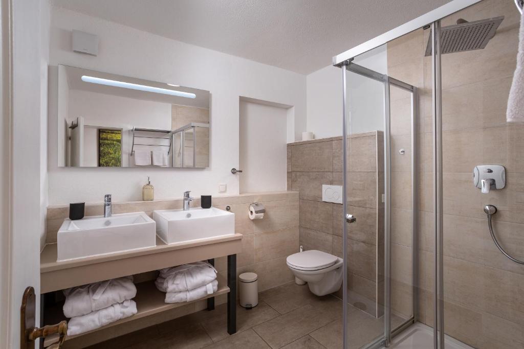 a bathroom with a sink and a toilet and a shower at Alpine View Apartments in Niedernsill