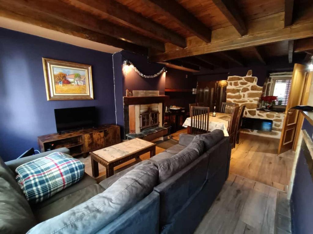 ein Wohnzimmer mit Couch und Kamin in der Unterkunft La Casita Violeta in Santa María de la Alameda