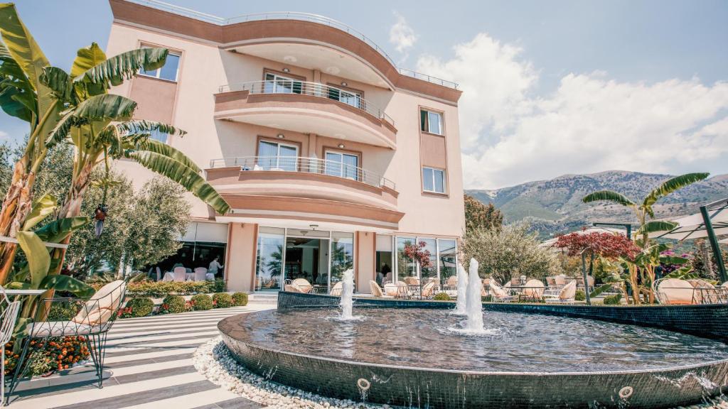 a building with a fountain in front of a building at Sole Luna Hotel in Borsh