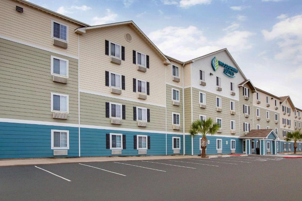 een groot appartementencomplex met een parkeerplaats bij WoodSpring Suites Brownsville in Brownsville