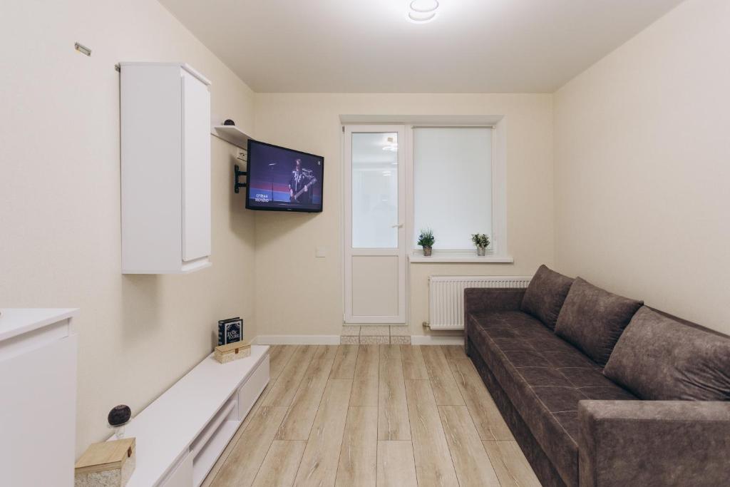 ein Wohnzimmer mit einem Sofa und einem Flachbild-TV in der Unterkunft Apart-smart 5.26 near Lavina 5 floor Kharkovskaya in Sumy