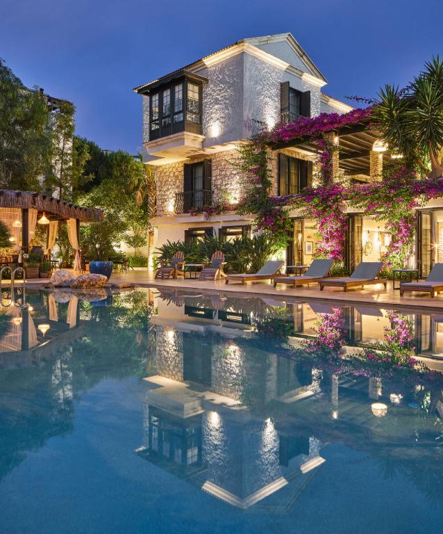 a house with a swimming pool in front of it at Alacatı Port Ladera Hotel - Adult Only in Alaçatı