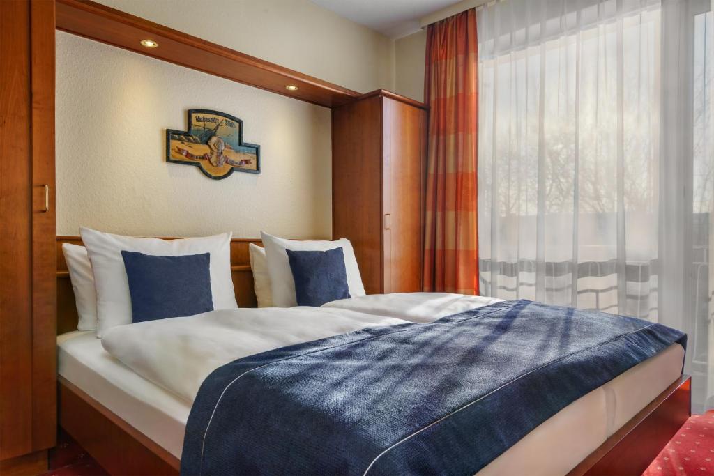 a large bed in a room with a window at Novum Hotel Hagemann Hamburg Hafen in Hamburg