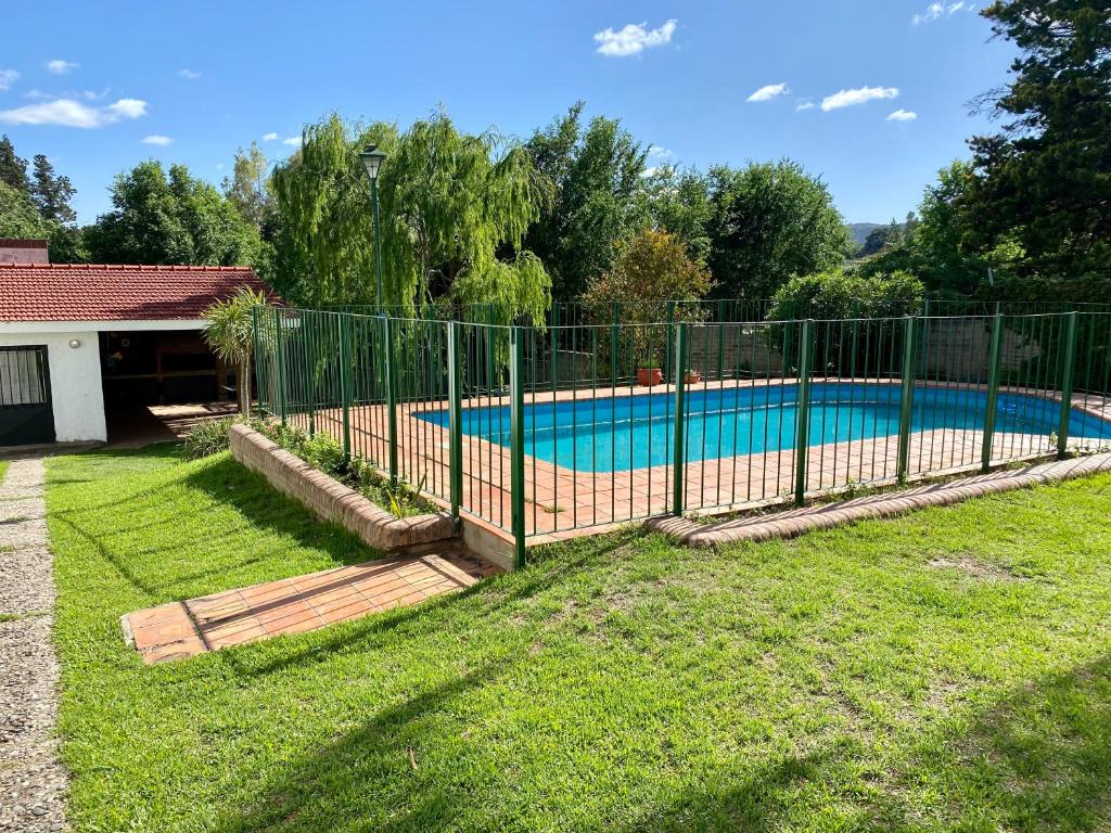 a fence around a swimming pool in a yard at La Casa de Tita in Villa Carlos Paz