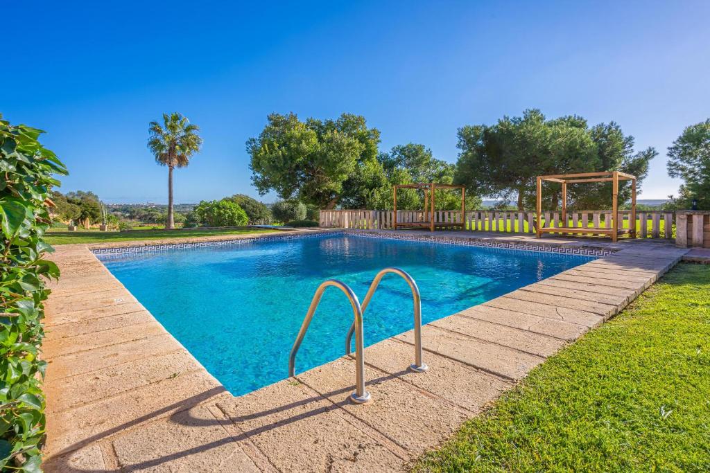 a swimming pool with a playground in a yard at Es turo de ses illes in Ses Salines