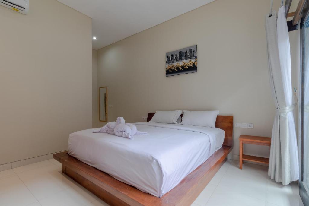 sypialnia z białym łóżkiem z pluszakiem w obiekcie Josh Guest House w mieście Singaraja