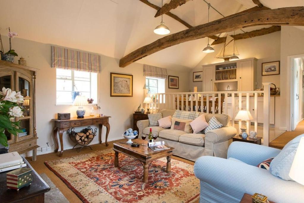 sala de estar con sofá y mesa en The Stables, relax in 5 star style and comfort with lovely walks all around, en Great Maplestead