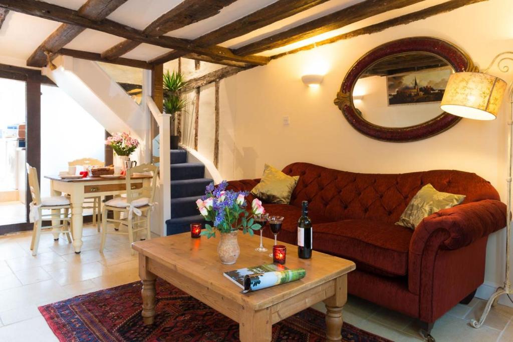 a living room with a couch and a table at Meddlars a historic cottage on the countryside edge of a vibrant Market Town in Hadleigh