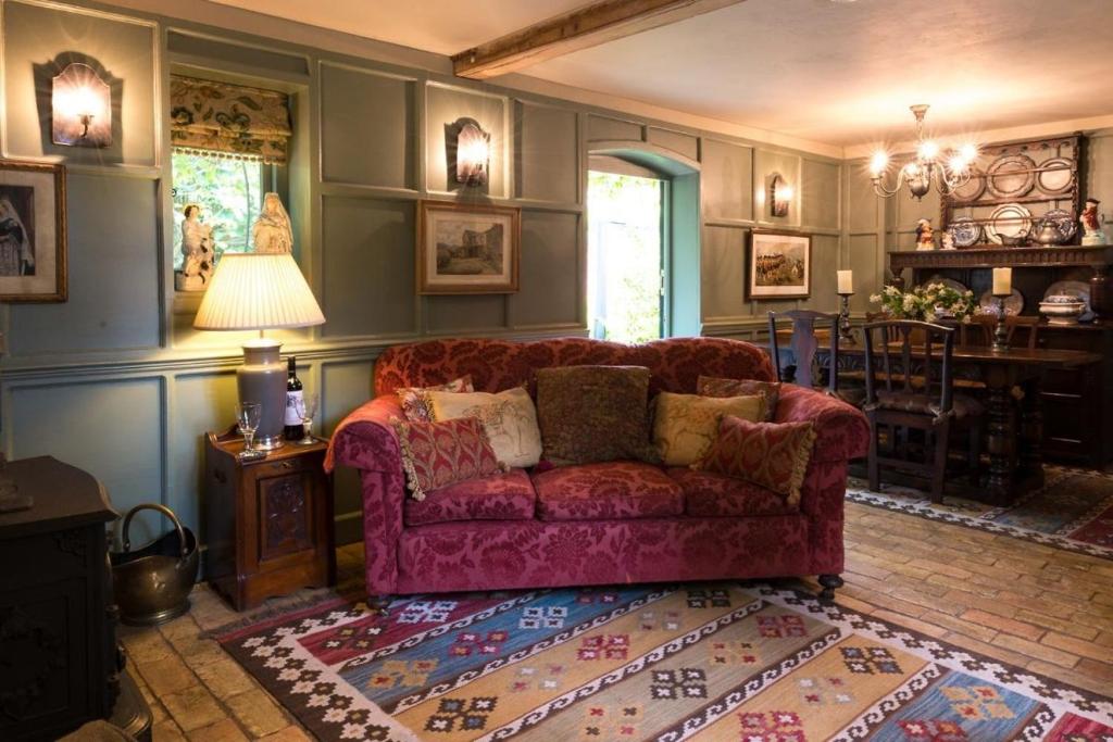 a living room with a red couch and a rug at Queenies, an authentic Rural Style coastal cottage in a Nature Reserve 