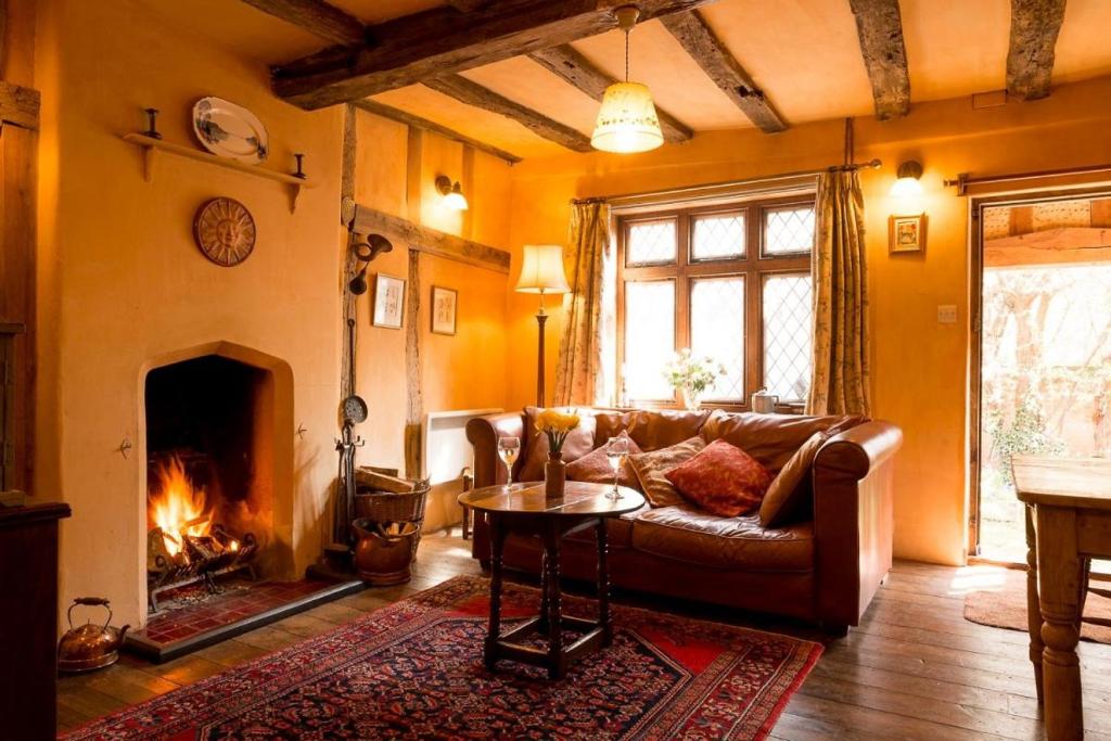 sala de estar con sofá y chimenea en The Old Monkey, a quirky bolthole on the edge of a historic Market Town en Hadleigh