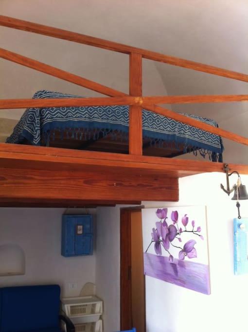 un letto a castello con un dipinto di fiori viola di Il Cubo, monovano col mare su tre fronti. a Favignana