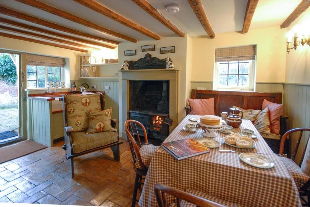 a dining room with a table and a fireplace at Laundry Cottage in a Nature Reserve - Sunday Times 100 coolest Cottages 