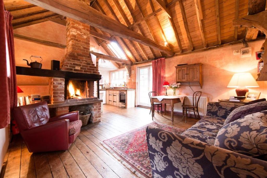 a living room with a couch and a fireplace at Rose Cottage rural cosiness with footpaths to the local Macro Brewery Pub 