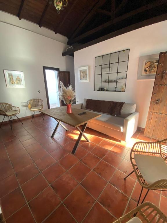 a living room with a couch and a table and chairs at CASA KIKA ROCIO in El Rocío