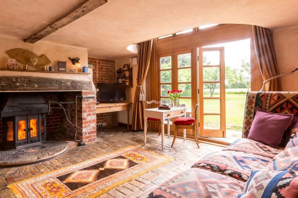 a living room with a couch and a fireplace at Dons Barn a Stunning cottage just a walk across the fields to a great pub 