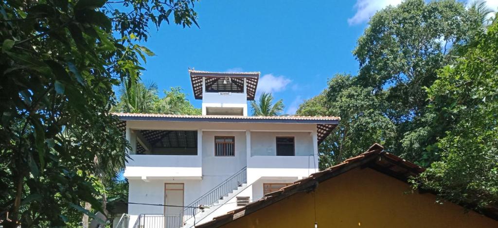 a white house with a tower on top of it at sunny mound unawatuna close by sri yoga shala in Unawatuna