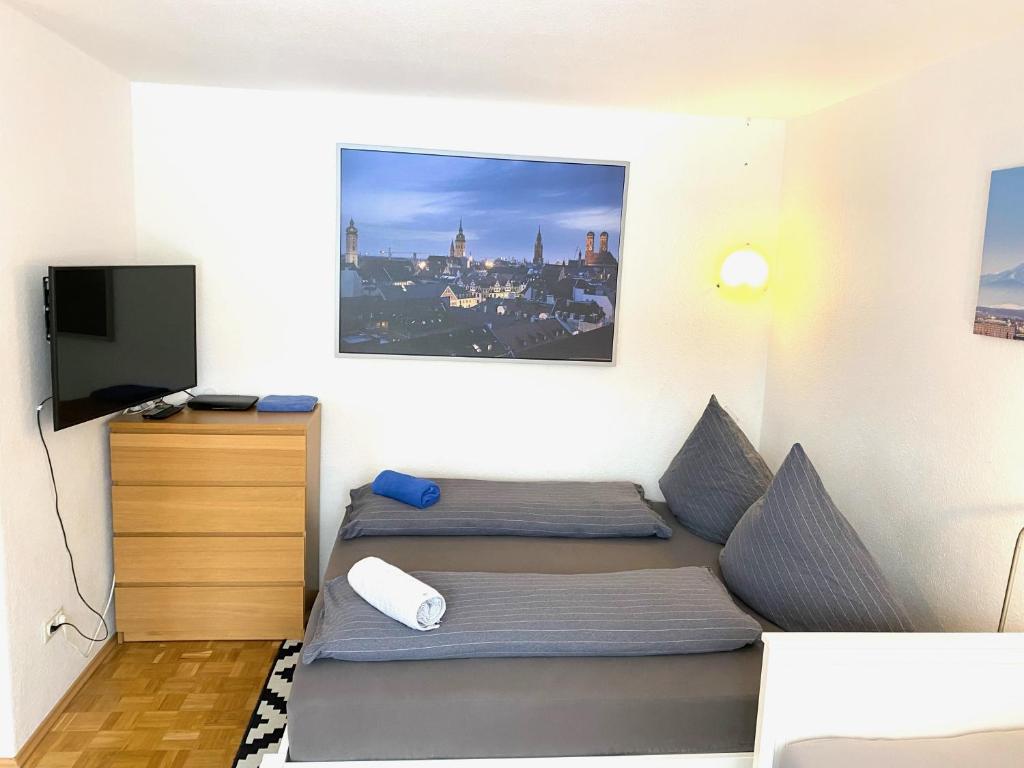 a small room with two beds and a television at Gemütliches Privatzimmer mit geteiltem Bad, Küche und Garten in Munich