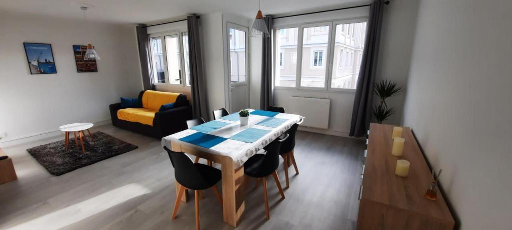 uma sala de estar com uma mesa e um sofá em Appartement Entre terre et mer em Dunkerque