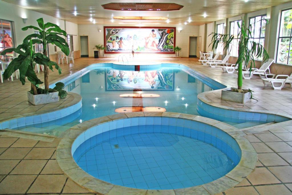 a large swimming pool in a hotel with blue tiles at Hotel Dona Beja in Araxá