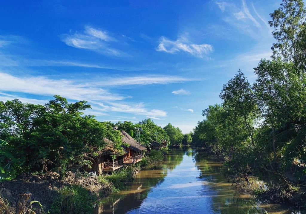 un fiume con alberi e case a lato di Hometravel Mekong Can Tho a Can Tho