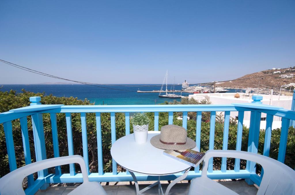 einen Tisch und Stühle auf einem Balkon mit Meerblick in der Unterkunft Asimina in Tourlos