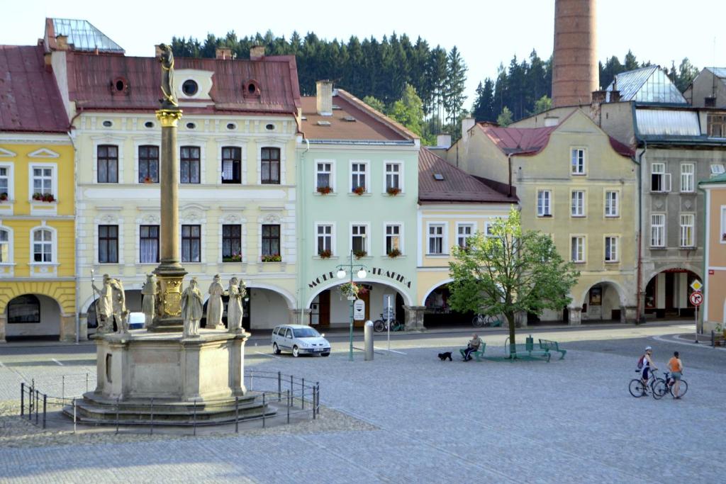 a fountain in the middle of a city with buildings at Apartmán Náměstí Hostinné in Hostinné