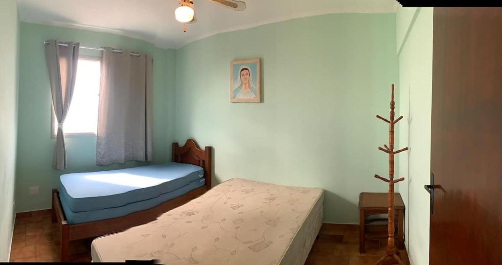 a small bedroom with two beds and a window at REFÚGIO DA SEREIA ARIEL in Mongaguá