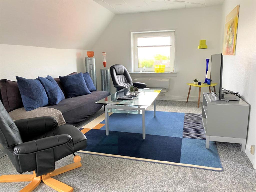 a living room with a couch and a table at Apartment med udsigt over Nordmors in Sejerslev