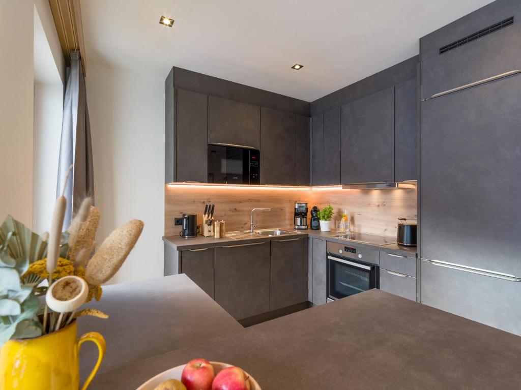 a kitchen with a table with a bowl of fruit at Isskogel Suites in Gerlos