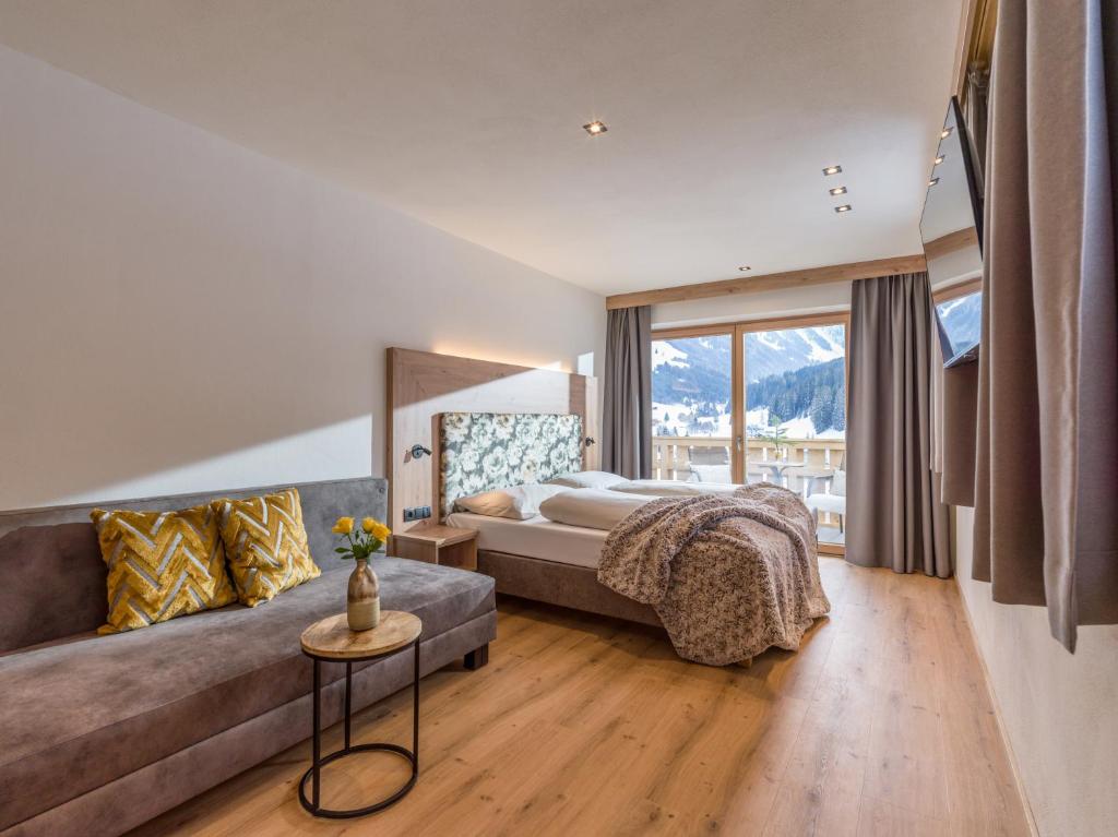 a bedroom with a bed and a couch at Isskogel Suites in Gerlos