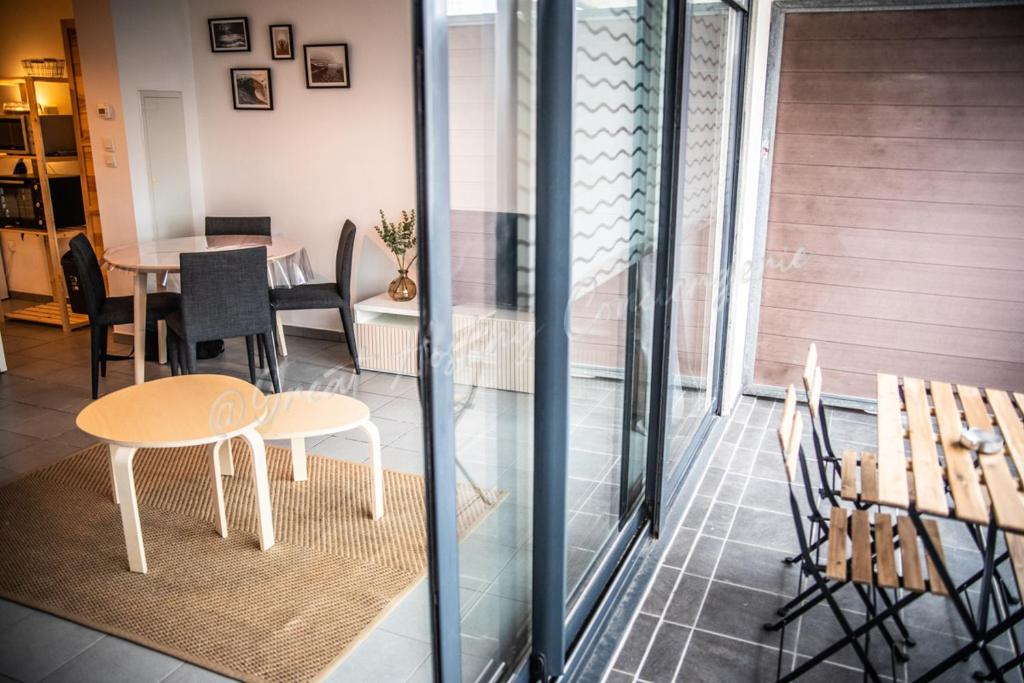 布賴迪訥的住宿－Le Samélie, Superbe appartement Bray-Dunes avec stationnement privatif，配有桌子、椅子和桌子的房间