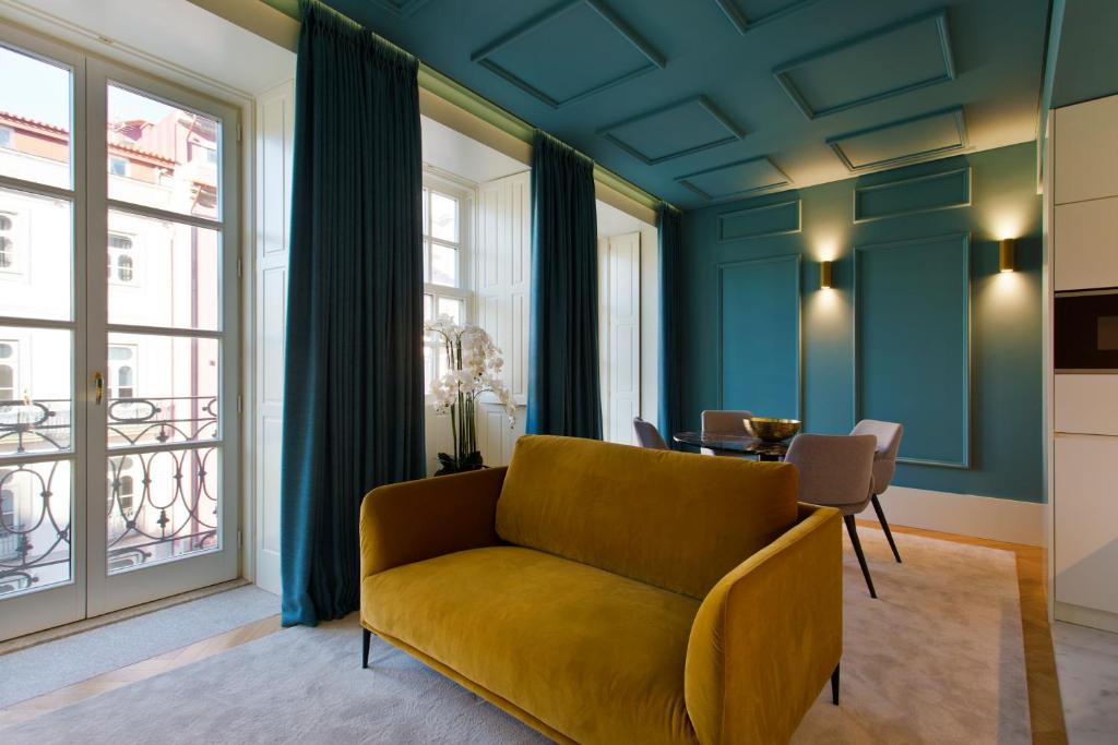 uma sala de estar com um sofá amarelo e uma mesa em BOUTIQUE Rentals-Kinga’s Ribeira River great views em Porto
