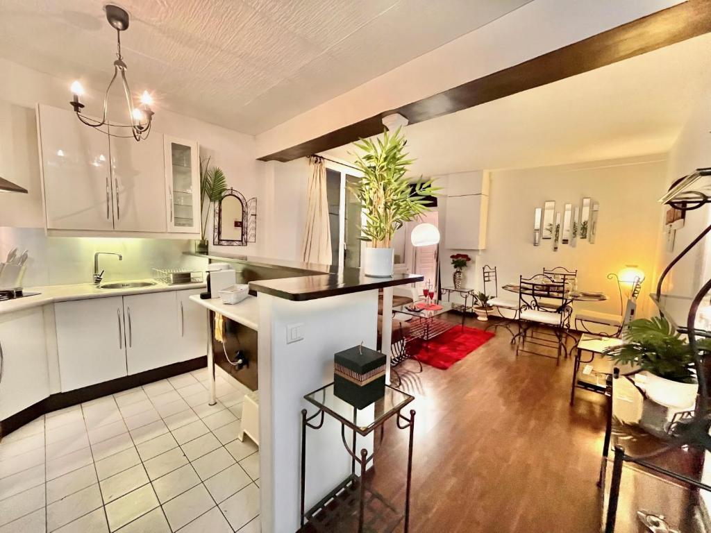 une cuisine avec des armoires blanches et un salon dans l'établissement Centre de Paris - Chez Aladdin - SOZEN, à Paris