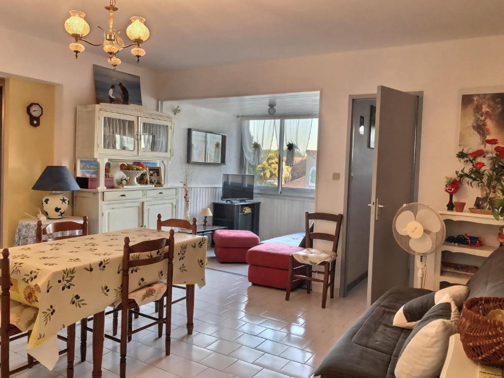 Il comprend une cuisine et un salon avec une table et des chaises. dans l'établissement Confortable appartement à 700m de la plage de Valras !, à Valras-Plage