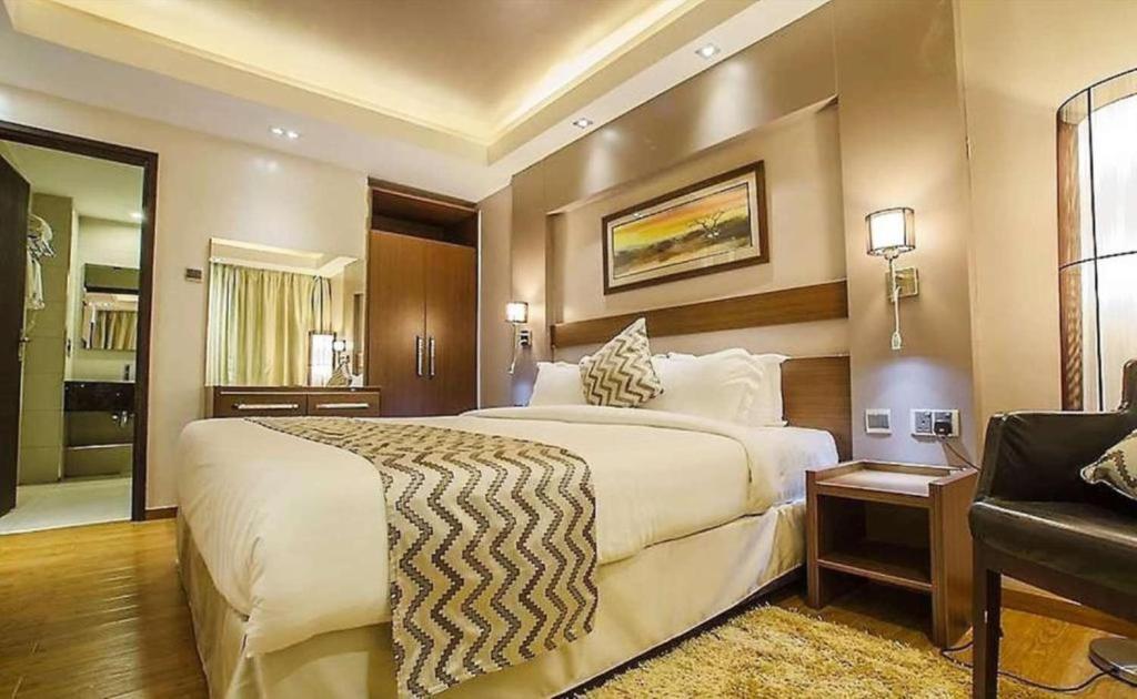 Habitación de hotel con cama grande y sofá en Ngong Hills Hotel, en Nairobi