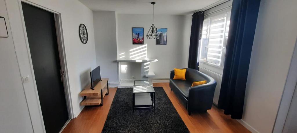 ein Wohnzimmer mit einem Sofa und einem TV in der Unterkunft Appartement Centre ville proche gare in Dunkerque