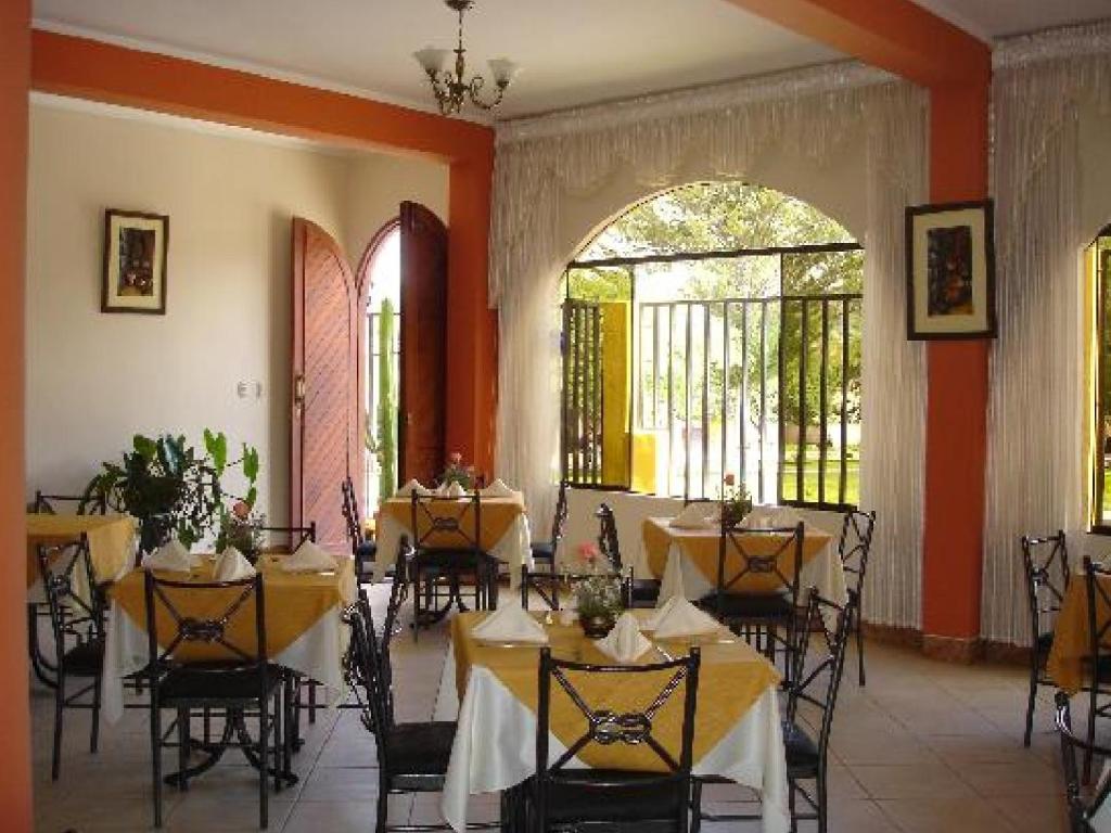 uma sala de jantar com mesas e cadeiras com toalha de mesa amarela em Hotel Sierra Dorada em Ayacucho