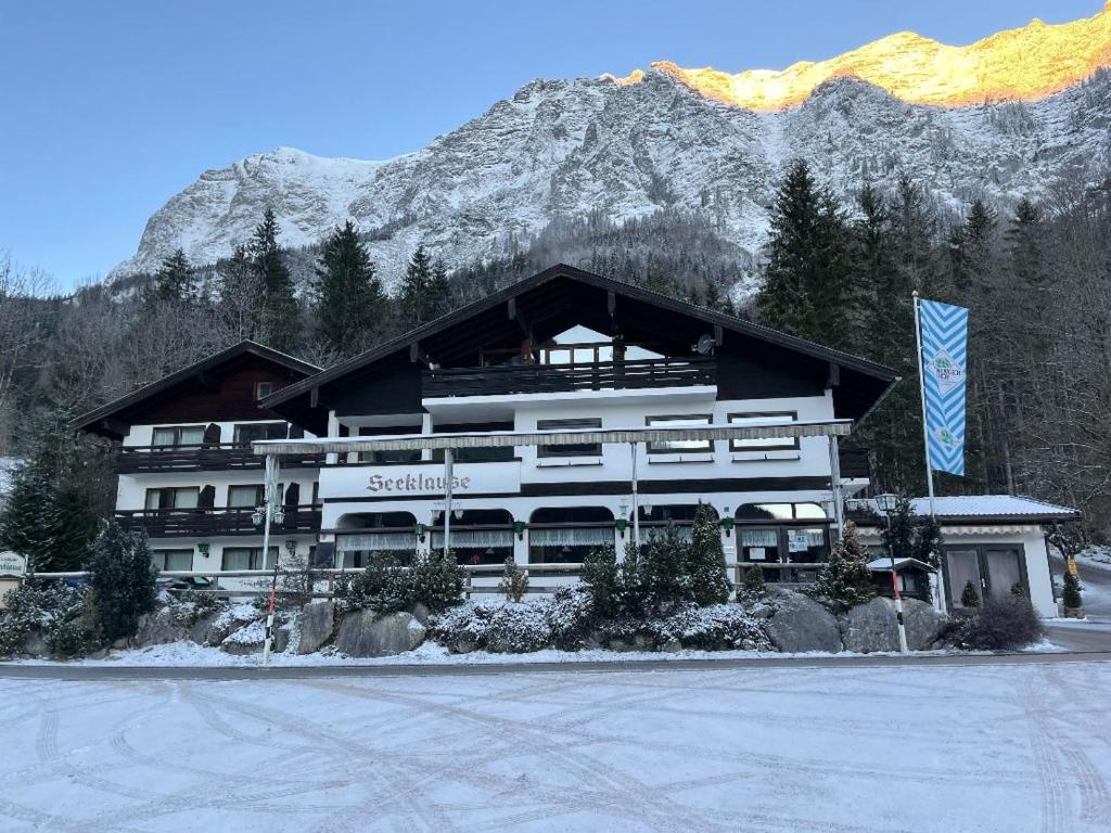 ein großes Gebäude vor einem Berg in der Unterkunft Gasthaus-Pension Seeklause in Ramsau bei Berchtesgaden